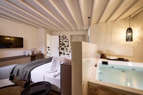 米克诺斯城Sharm Hotel Mykonos的一间卧室配有一张床和浴缸