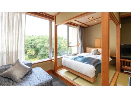 新发田市Tsukioka Onsen Furinya - Vacation STAY 55981v的一间卧室设有一张床和一个大窗户