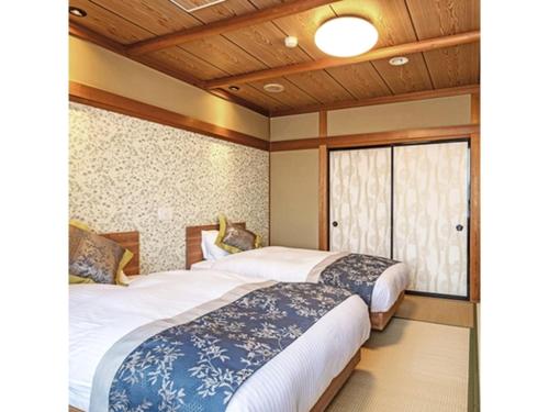 新发田市Tsukioka Onsen Furinya - Vacation STAY 55991v的带窗户的客房内的两张床