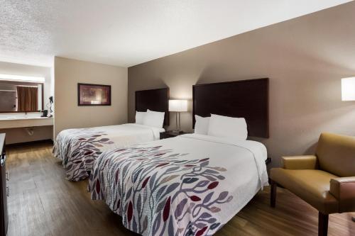 哥伦比亚Red Roof Inn Columbia, SC Airport的酒店客房,配有两张床和椅子