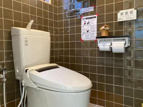 伊势市Minpaku Yagi - Vacation STAY 14700的浴室设有白色卫生间,位于瓷砖墙壁上