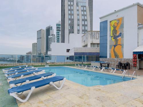 卡塔赫纳Hotel Costa del Sol的一座带躺椅的游泳池以及一座壁画
