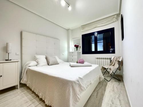 诺哈La Goleta - 6915的一间白色卧室,配有一张大床和一台电视