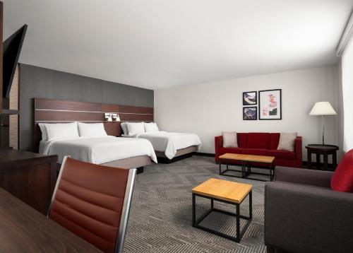 西切斯特辛辛那提北/西切斯特福朋喜来登酒店的酒店客房带两张床和一张红色沙发