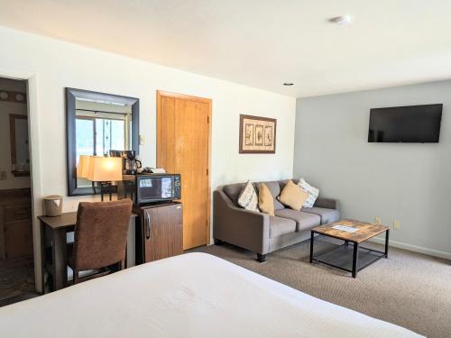 格兰德莱克Western Riviera Lakeside Lodging的酒店客房配有床、沙发和桌子。