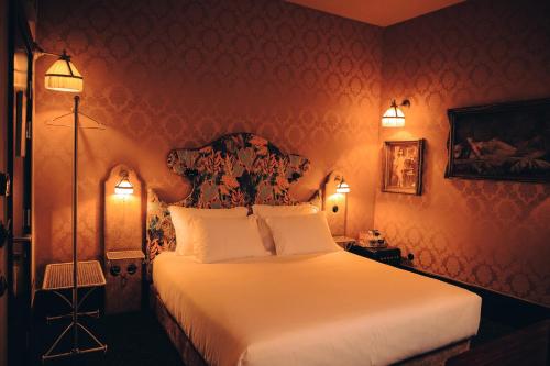 里斯本Pensão Amor Madam's Lodge的卧室配有一张带两个灯的大白色床