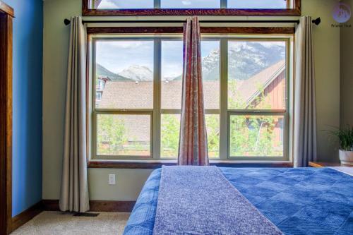 坎莫尔Fire Mountain Two Bedroom Condo的一间卧室设有大窗户和一张蓝色的床