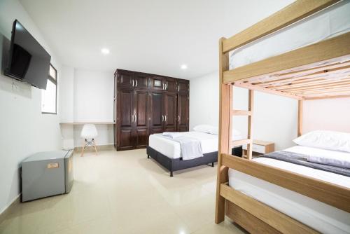 麦德林Experiencia Única Habitación Privada en Medellín A的一间卧室配有两张双层床和一台平面电视