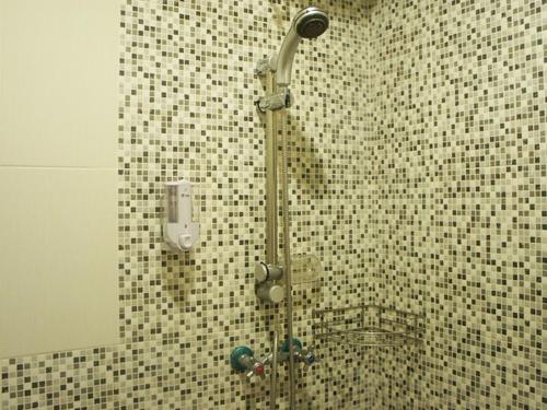 库塔瓦纳库布寄宿家庭旅馆的带淋浴的浴室(带瓷砖墙)