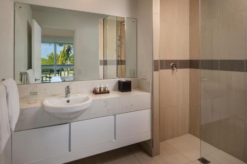 丹娜努丹娜拉露台公寓式酒店的浴室配有盥洗盆和带镜子的淋浴