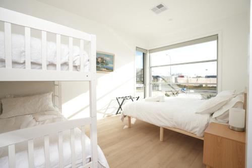 金德拜恩Powder Peaks的白色的卧室设有双层床和窗户。