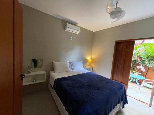 皮雷诺波利斯Confraria da Prata Flats的一间卧室配有一张带蓝色毯子的床和窗户。