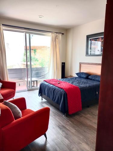 瓦哈卡市Casa del Pibe Piola的一间卧室配有一张床、一张沙发和一个窗口