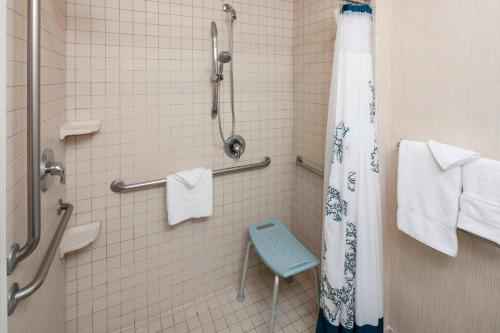 土桑图森机场原住客栈的浴室设有蓝色凳子和淋浴