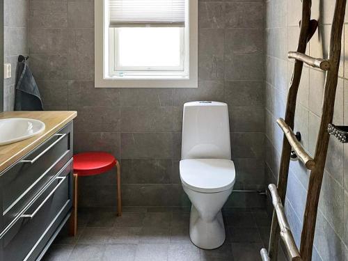 内斯比恩Holiday home NESBYEN III的浴室设有白色卫生间和红色凳子。