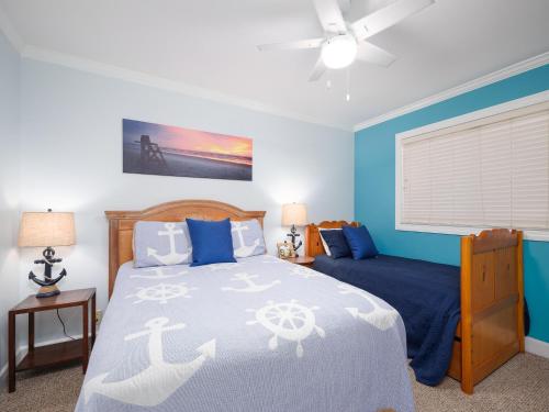 圣奥古斯丁Hibiscus 201-D, 2 Bedrooms, Ocean View, 3 Pools, Spa, Sleeps 6的一间拥有蓝色墙壁的卧室、一张床和窗户