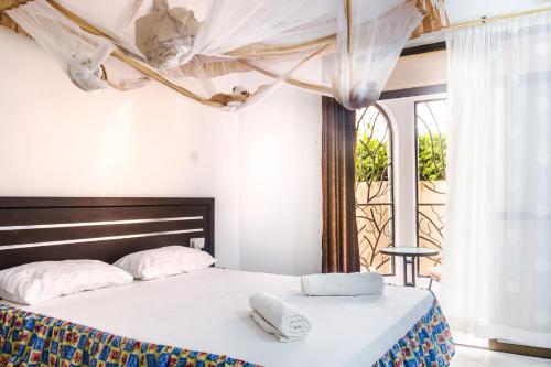 迪亚尼海滩Uhai Vacations的一间卧室配有一张床,上面有两条毛巾