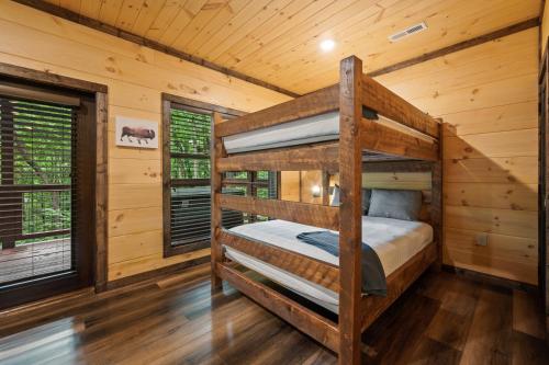 加特林堡New Cozy Mountain Cabin Hot Tub Near Downtown的小木屋内一间卧室配有两张双层床