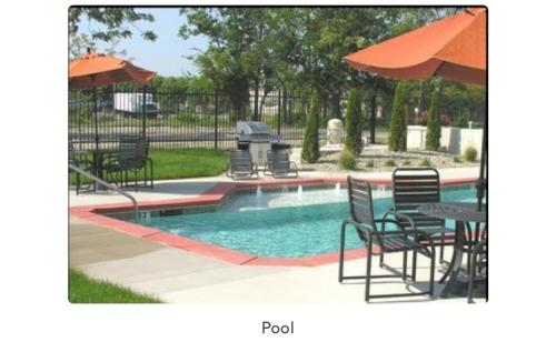 圣路易斯Luxury Cozy Loft Downtown STL的一个带桌椅和遮阳伞的游泳池