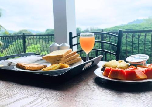 康提Hanthana Mount View的一张桌子,上面放着一盘食物和一杯橙汁