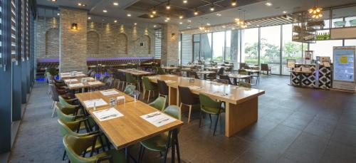 昌原市Grand City Hotel Changwon的餐厅设有木桌和绿色椅子