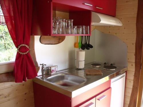 FerdruptGîte Ferdrupt, 2 pièces, 2 personnes - FR-1-589-444的厨房配有水槽和红色窗帘