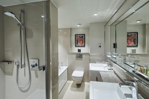 伦敦万豪伦敦肯辛顿度假酒店的一间带两个盥洗盆、卫生间和淋浴的浴室