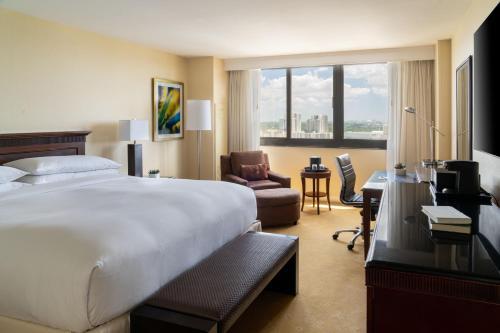 迈阿密迈阿密戴德兰万豪酒店的酒店客房配有一张床、一把椅子和一张书桌