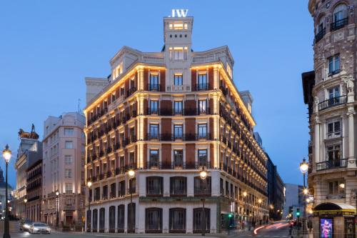 马德里JW Marriott Hotel Madrid的夜空在城市街道上被点燃的建筑物