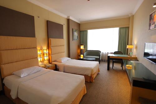 米里美里王朝酒店的酒店客房设有两张床和电视。