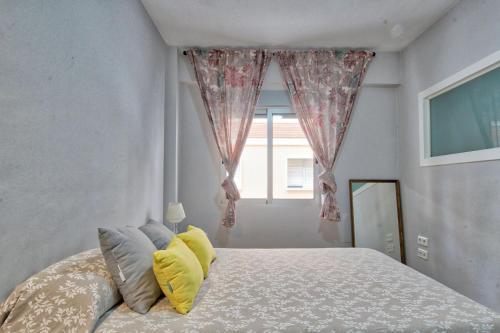 穆尔西亚Lujoso apartamento en el centro de la ciudad的一间卧室配有一张带黄色枕头的床和一扇窗户