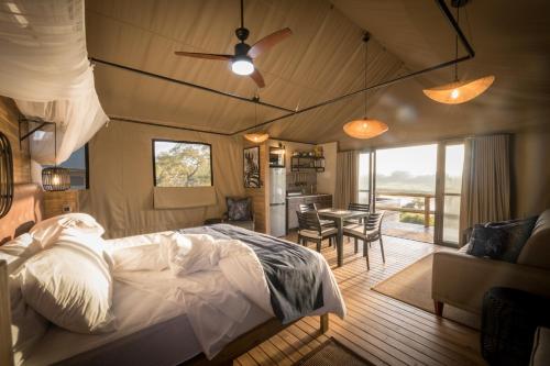 斯库库扎Nkuhlu Tented Camp的一间卧室设有一张床和一间用餐室