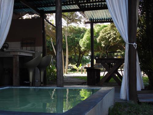 普拉伊拉多比莱尼Shongili Island Lodge的一个带凉亭和野餐桌的游泳池