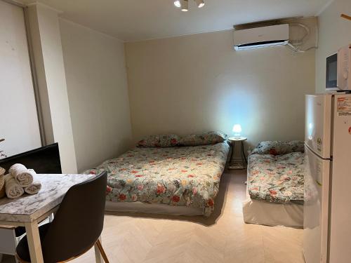 首尔Rich House Dongdaemun的小房间设有两张床和一台冰箱