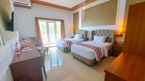吉利特拉旺安Gili Beachfront Suites的酒店客房配有两张床和一张书桌