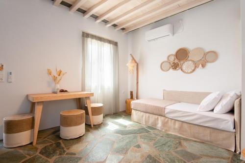 瓦西Thimari villas的白色的客房配有一张床和一张桌子
