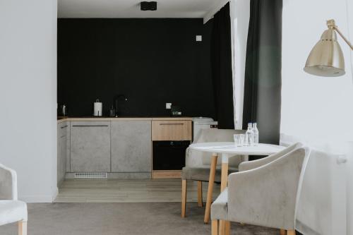 卡托维兹Silesia Apartments的厨房配有桌椅和黑色墙壁