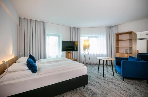 维也纳ARCOTEL Wimberger Wien的酒店客房,配有一张床和一张蓝色椅子