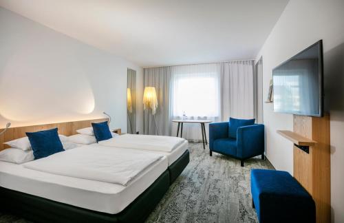 维也纳ARCOTEL Wimberger Wien的酒店客房带大床和蓝椅