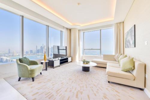 迪拜Ultra Luxury Palm Tower with Shared 5 Star Hotel Facilities的带沙发、椅子和窗户的客厅