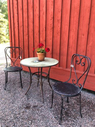 ForshagaLillemyrsgården的两把椅子和一张桌子上放着盆子