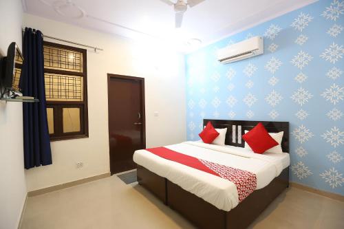 Garhi HarsāruOYO Flagship 44151 Royal Guest House的一间卧室配有一张带红色枕头的床