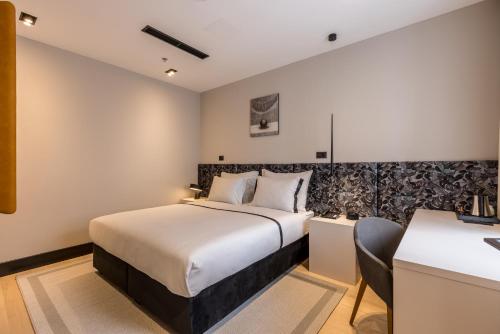 斯普利特Cora Hotel的酒店客房设有一张大床和一张书桌。