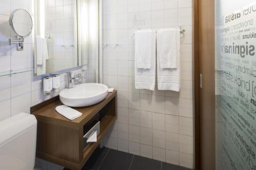 莱克斯西格妮娜酒店的一间带水槽、卫生间和镜子的浴室