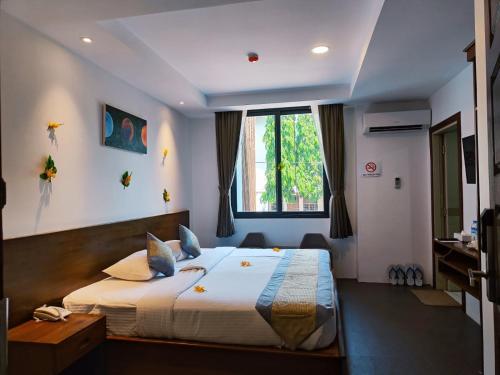 仰光Yangon Win Hotel的一间卧室设有一张大床和一个窗户。