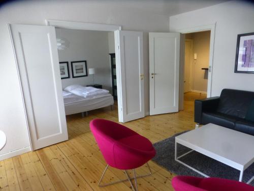 哥本哈根Christianshavn Apartments 536的客厅配有红色椅子和沙发