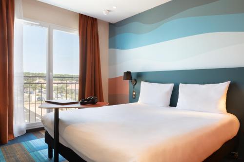 米拉马斯Ibis Styles Miramas的酒店客房设有床和窗户。