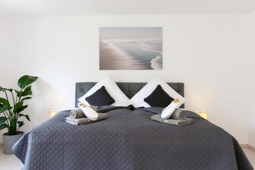 伍珀塔尔Luxus über 2 Etagen mit Balkon in Elberfeld的一间卧室配有带两个枕头的床和一幅画