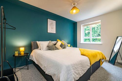 诺丁汉2 bed apartment Close to the Nottingham City Centre的一间卧室配有一张蓝色墙壁的床