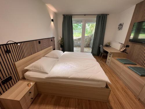 韦莱涅Prenočišča Mraz的卧室设有一张白色大床和一扇窗户。